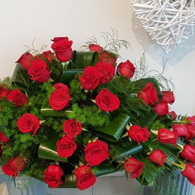 Composition with red roses in container